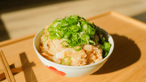 Chopsticks next to a bowl of Sake Teriyaki Takikomi Gohan (Japanese Mixed Rice with Salmon Teriyaki and Mushrooms)